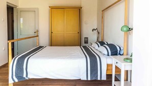 Une chambre à coucher avec un lit, une table de chevet, une lampe et une armoire.