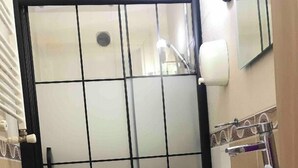 A bathroom with a toilet, a sink, and a shower enclosure. - Yed Hotel (Istanbul)