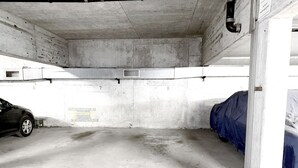 A parking garage with concrete walls, numbered parking spaces, and a car parked in one of the spaces. - Spacious Design Retreat for Groups & Families (Stuttgart)