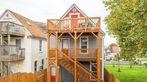 A multi-story wooden house with a balcony, a staircase, and a fenced yard. - Beautiful Victorian Home (Tacoma)