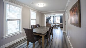 A dining area with a rectangular table and six chairs, a hallway with a door leading to another room, and a painting on the wall. - Beautiful Victorian Home (Tacoma)