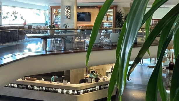 A modern lobby with a central island, seating area, and a large window providing natural light.