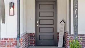 Une porte d’entrée avec une boîte aux lettres et un panneau indiquant une liste d’activités.