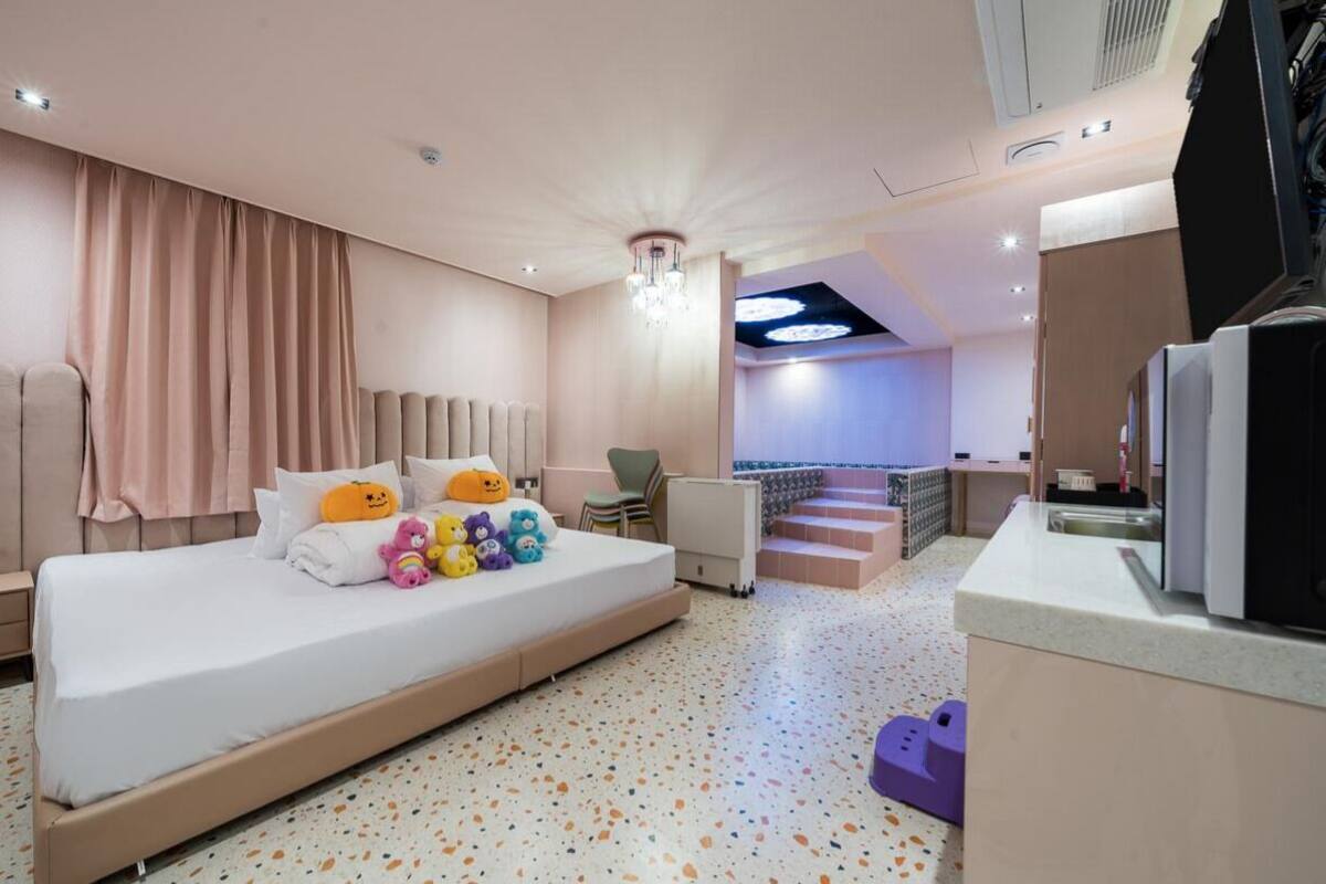 Een moderne hotelkamer met een groot bed, een bureau en een televisie.