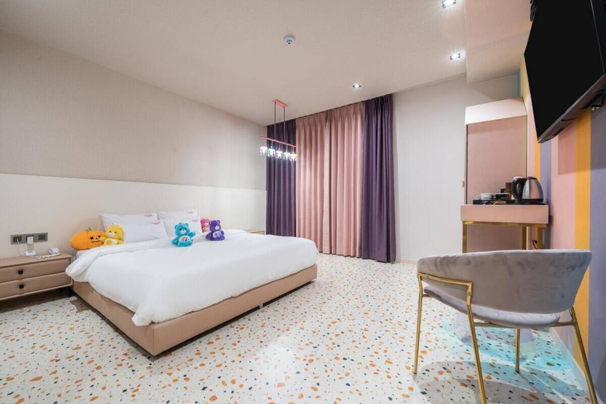Een moderne hotelkamer met een groot bed, een bureau, een stoel en een televisie.
