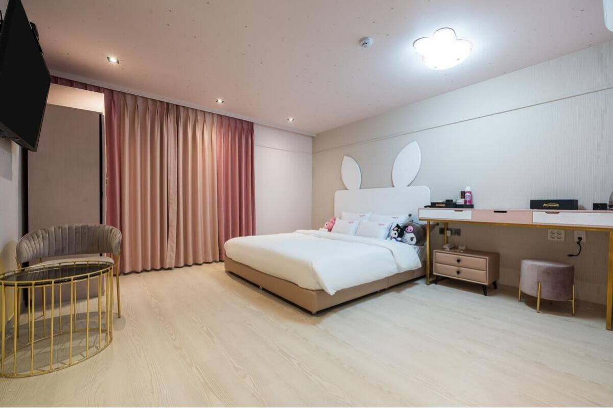 Een moderne hotelkamer met een bed, bureau, stoel en televisie.