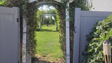 A gated entrance with a pathway leading to a grassy yard.
