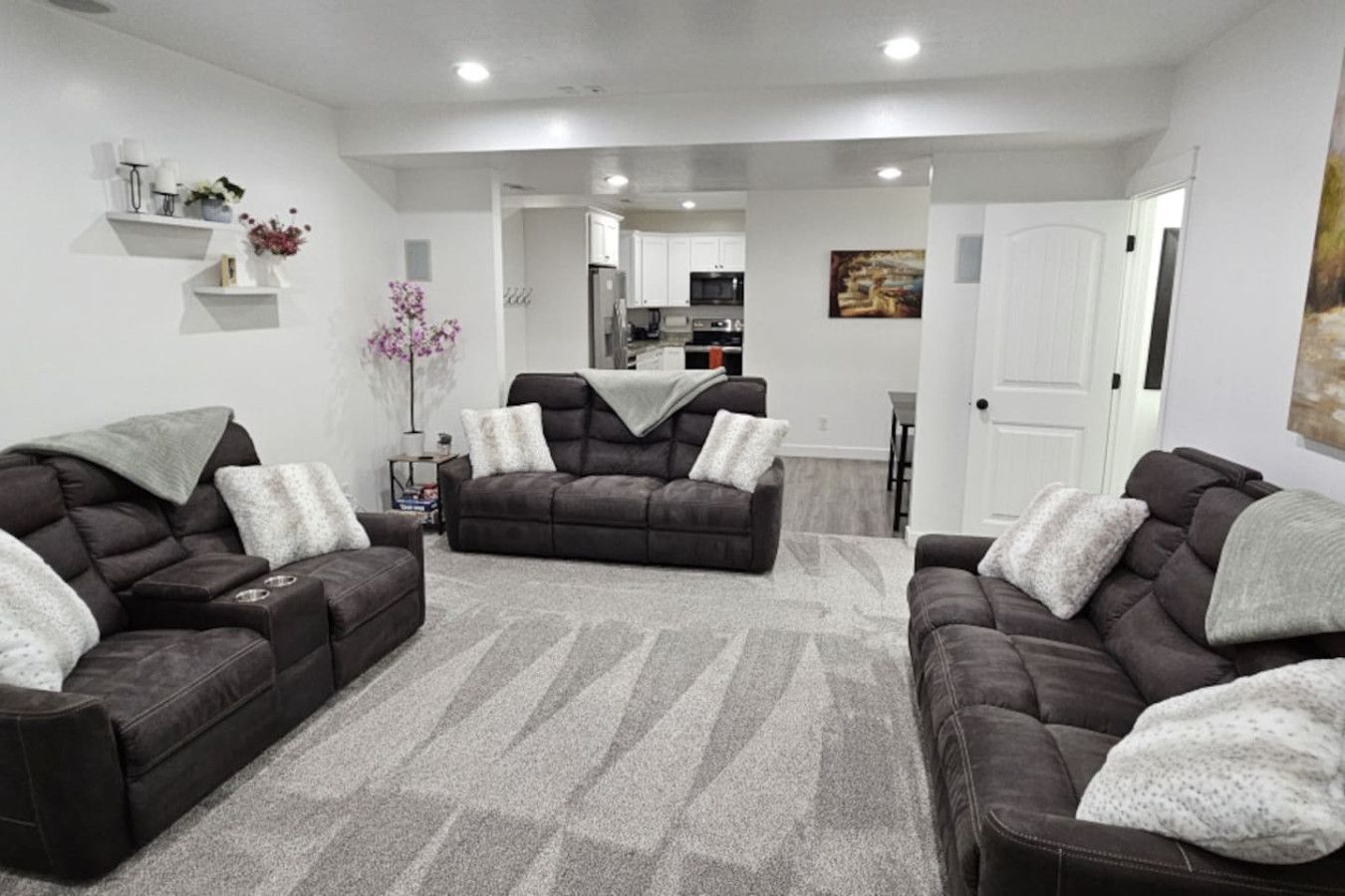 A living room with two dark sofas, a coffee table, and a grey patterned rug.