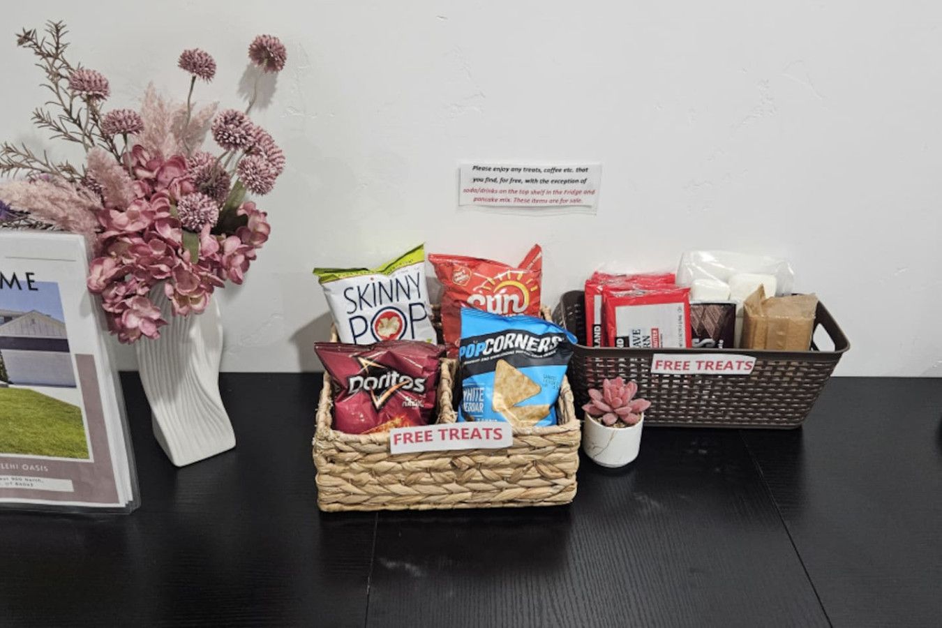 A table with snack baskets labeled 'FREE TREATS' and a sign indicating complimentary treats.