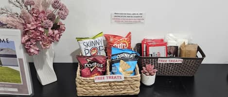 A table with snack baskets labeled 'FREE TREATS' and a sign indicating complimentary treats.