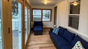 Ein Zimmer mit Holzboden, einem blauen Sofa und einer Deckenleuchte.