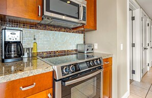 Una cocina equipada con microondas Bosch, cafetera, tostadora y estufa.