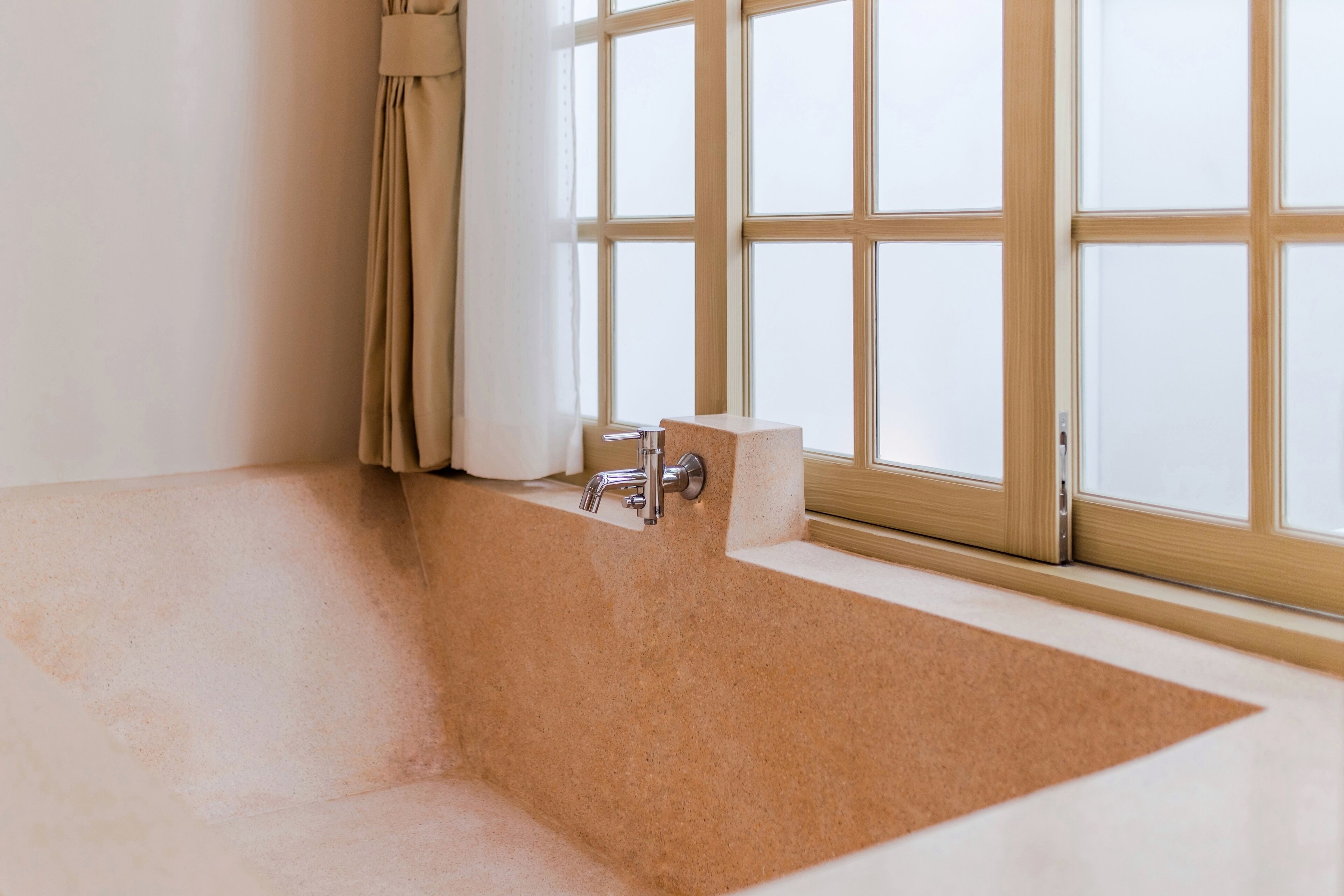 A bathroom with a bathtub, a window with frosted glass, and a towel rack.