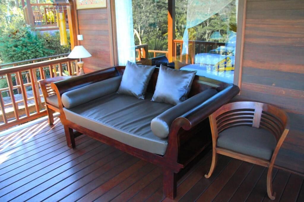 A wooden deck with a sofa and a chair.