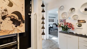 A modern kitchen with a traditional Japanese artwork, a hanging light fixture, and a clock on the wall. - Holiday Apartment 'Baden - Baden International' with Wi-Fi (Baden-Baden)