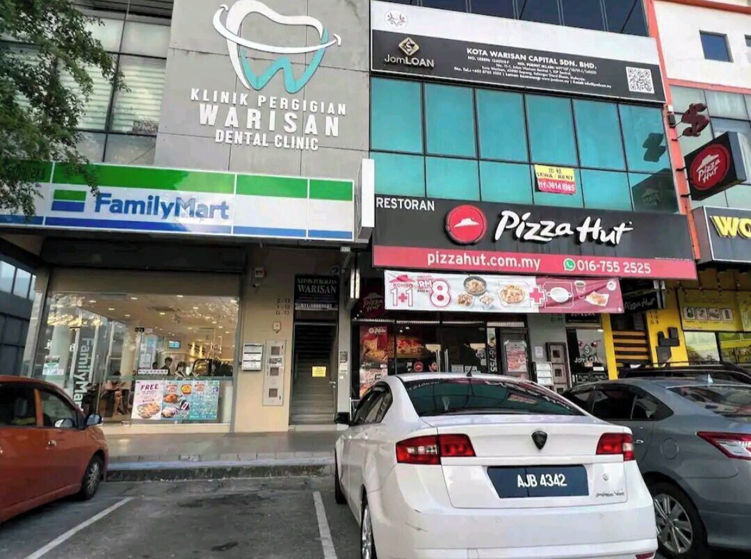A building with a dental clinic, a FamilyMart, and a Pizza Hut.