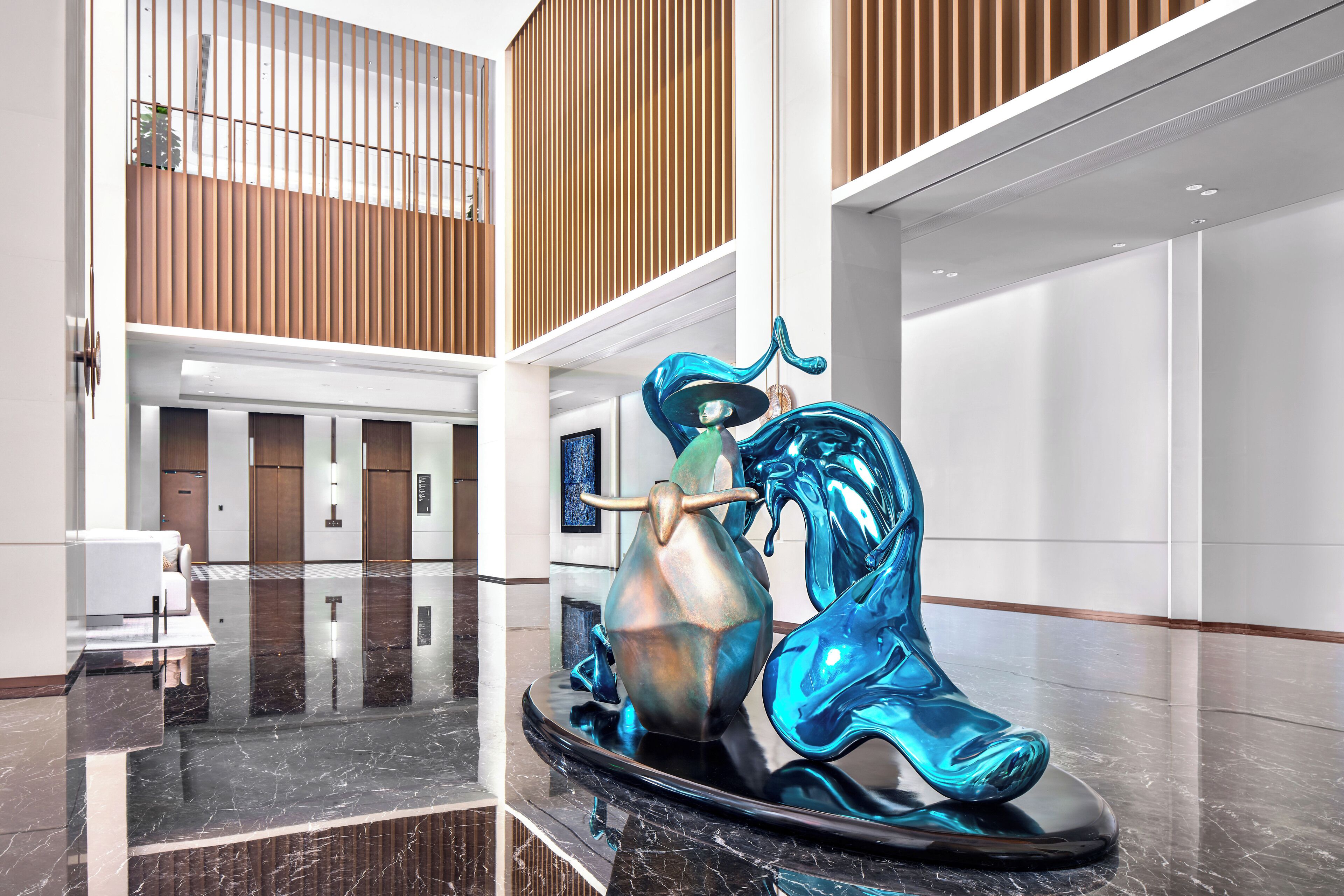 A modern lobby with a reflective floor, a unique sculpture, and a seating area.