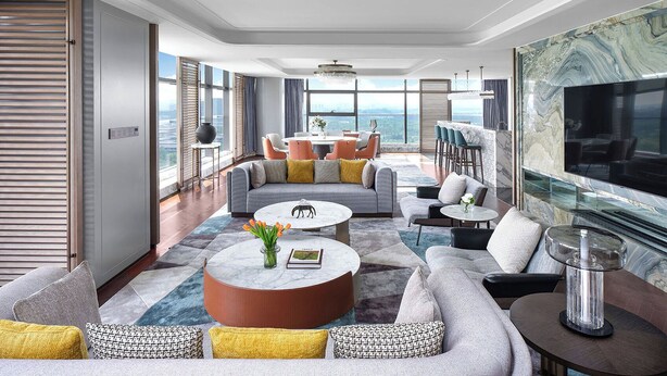 A modern living room with a large window, a round coffee table, and a flat-screen TV mounted on the wall. - Cordis, Xuzhou (Xuzhou)