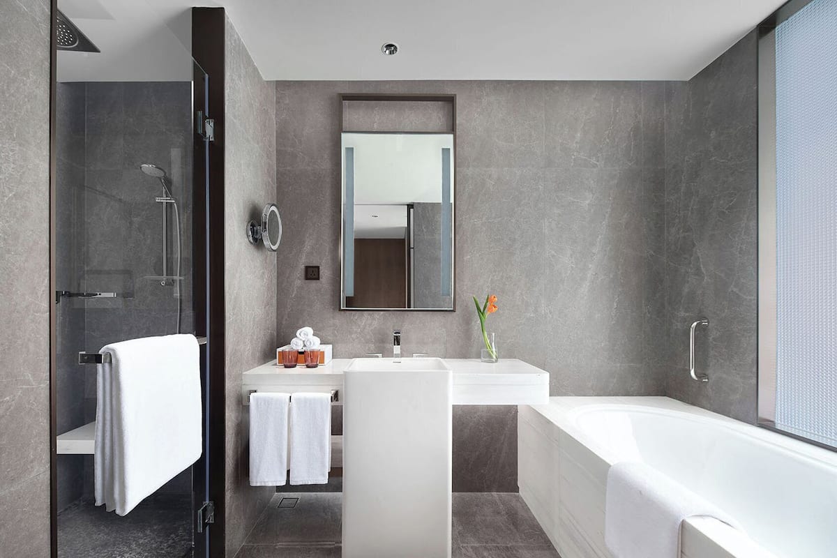 A modern bathroom with a shower, sink, and bathtub.