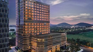 A modern hotel with a prominent 'CORDIS' sign, featuring a multi-story structure with a glass facade and a landscaped courtyard. - Cordis, Xuzhou (Xuzhou)
