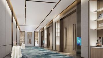 Stylish corridor with a patterned carpet, digital display, and artwork.