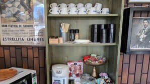 A restaurant interior with a menu board, coffee machine, and shelves with cups and condiments. - Hotel CAMELOT (Fujikawaguchiko)