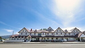 A large, multi-story hotel with a symmetrical facade, multiple balconies, and a central entrance. - Hotel CAMELOT (Fujikawaguchiko)