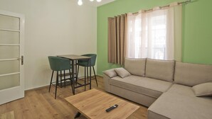 A living room with a sofa, two chairs, a coffee table, and a door. - Aristea in Athens With 2 Bedrooms and 1 Bathrooms (Athens)