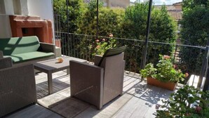 A balcony with wicker furniture, a green sofa, and potted plants. - Cozy apartment in Old City Center up to 4 people with a Large Terrace (İstanbul)