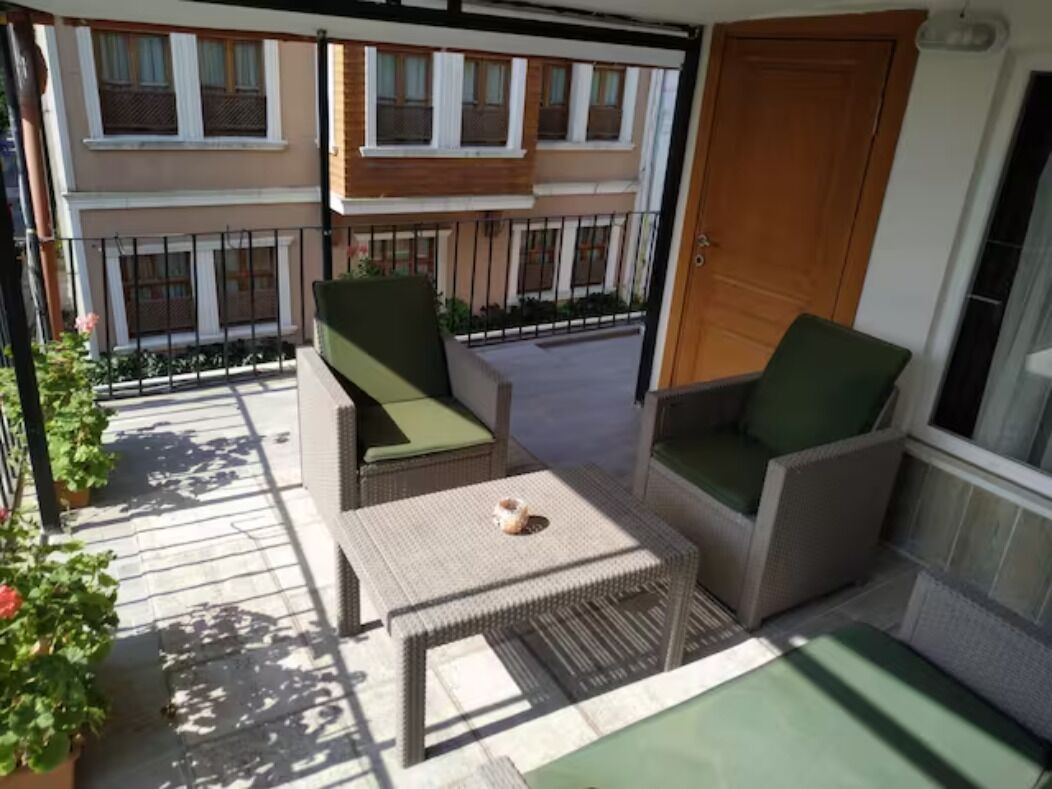 A balcony with wicker furniture, a small table, and a door.