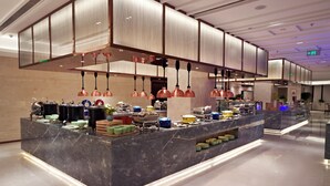 A modern buffet setup with a marble counter, copper pendant lighting, and a variety of food containers. - The Farrington Hotel - Building B (Weifang)