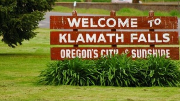 Willkommensschild für Klamath Falls, Oregon, Stadt und Sonnenschein.