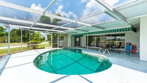 Ein überdachter Pool im Freien mit Glaskuppel, eine Terrassenfläche mit Stühlen und Blick auf die umliegende Landschaft.