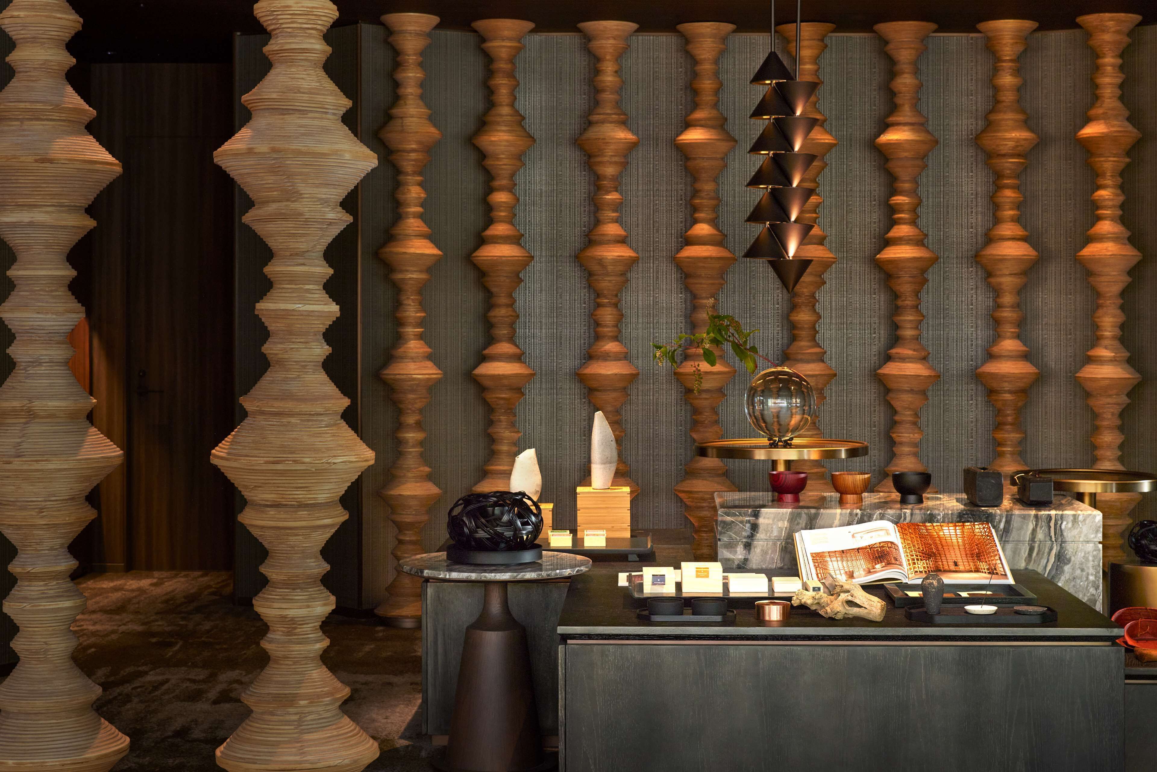 A room with a wooden columned wall, a round table with a book, and various decorative items.