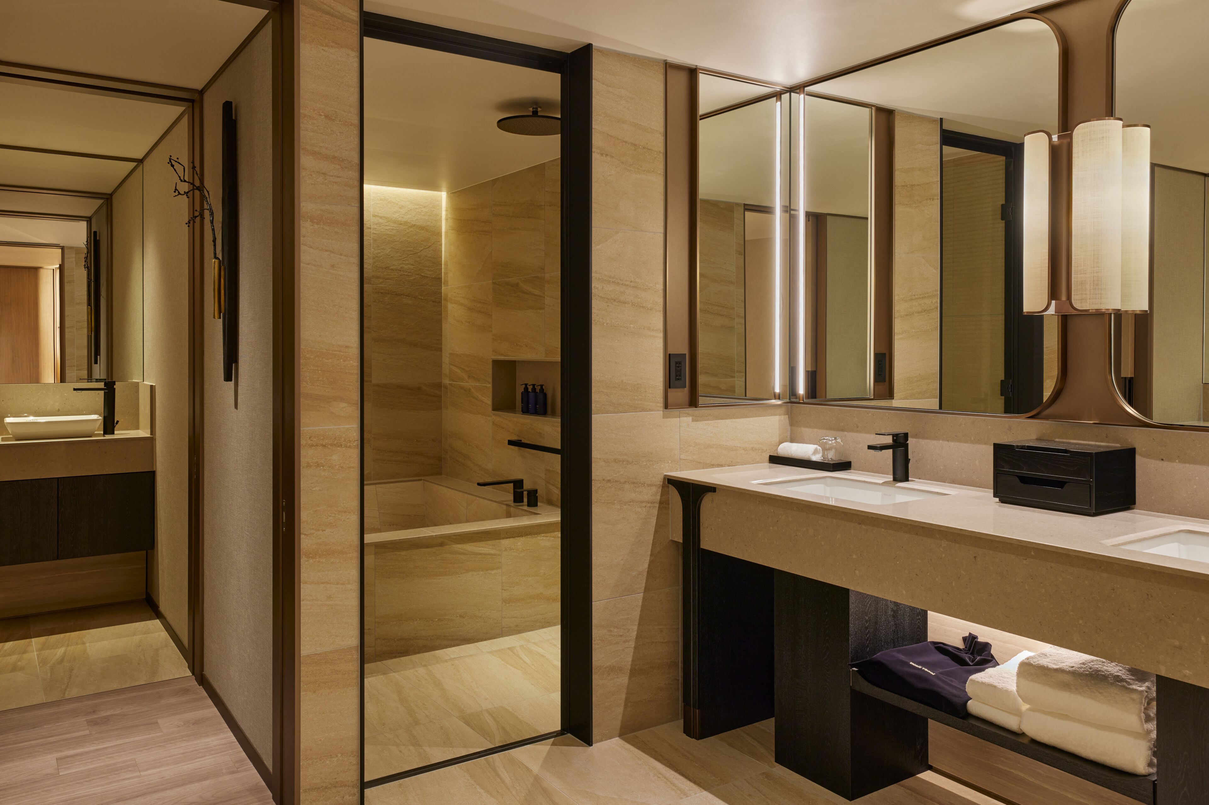 A modern bathroom with a large mirror, a bathtub, and a vanity with a sink.