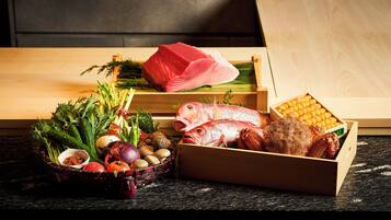 A variety of fresh seafood and vegetables on a wooden table.