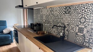 Una cocina moderna con encimera de madera, pileta negra y salpicadero con diseño.