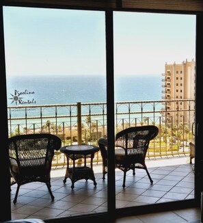 A balcony with wicker furniture and a view of the ocean. - Incredible view in Bella Sirena (Puerto Peñasco)