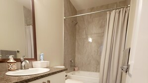 A modern bathroom with a sink, toilet, and shower. - Family-friendly, clean & affordable 2-BR basement suite close to YEG airport. (Edmonton)
