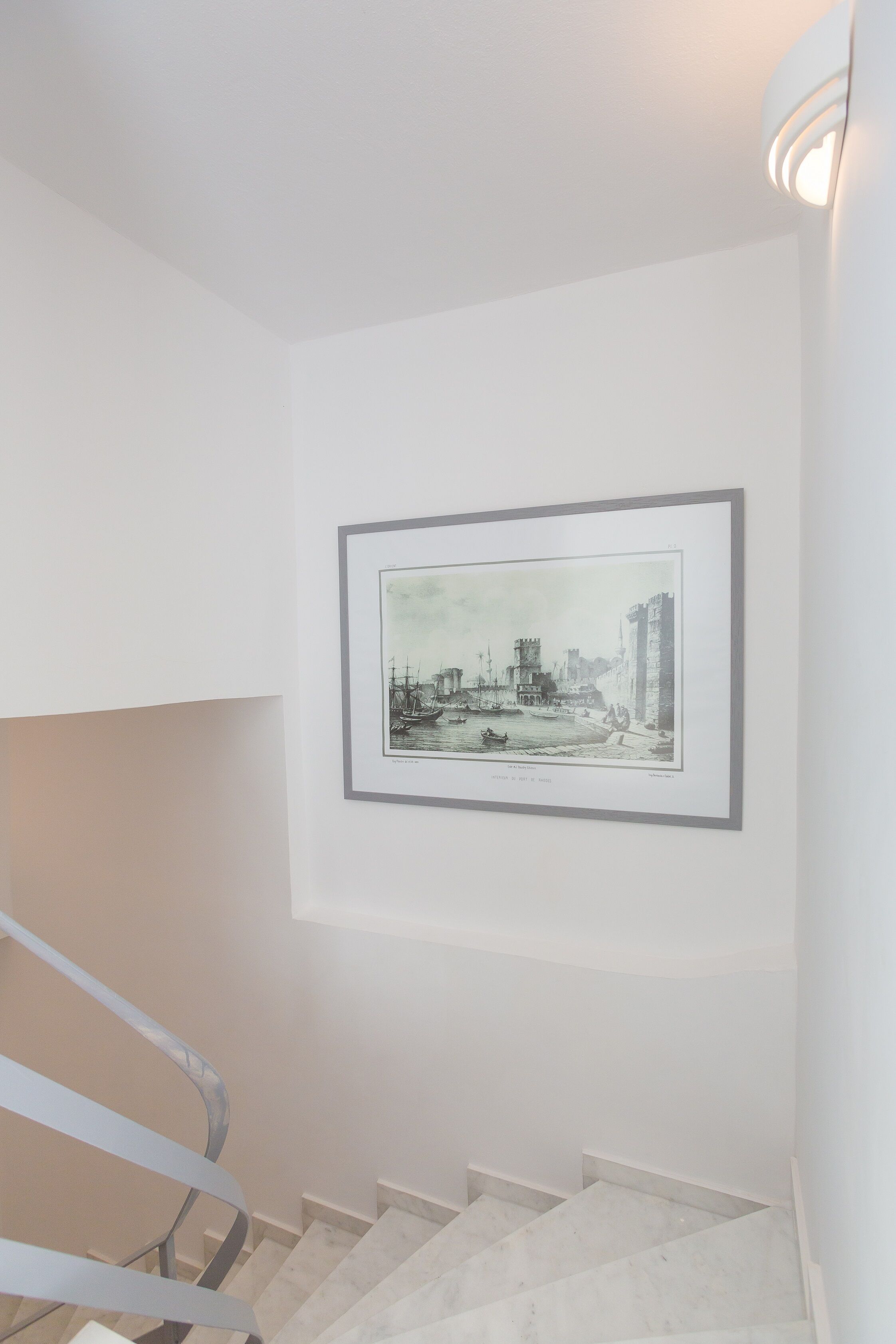 A staircase with a framed historical illustration on the wall above it.