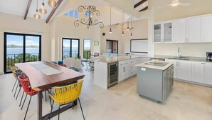 A spacious kitchen with a central island, large windows, and a view of the outdoors.
