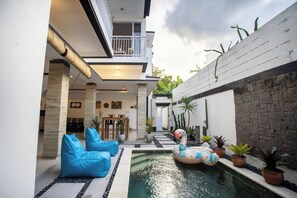 Relax by the pool surrounded by lush greenery and enjoy the view from the balcony.