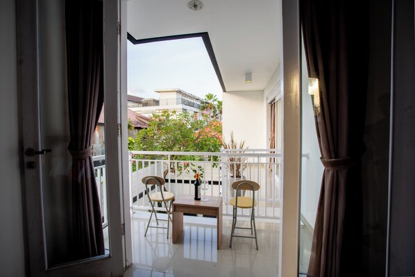 Enjoy the view from this balcony with a clear view of the surrounding buildings, featuring a comfortable seating area with a table and chairs.