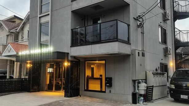 A modern hotel entrance with a glass door, a visible reception area, and a vehicle parked outside.
