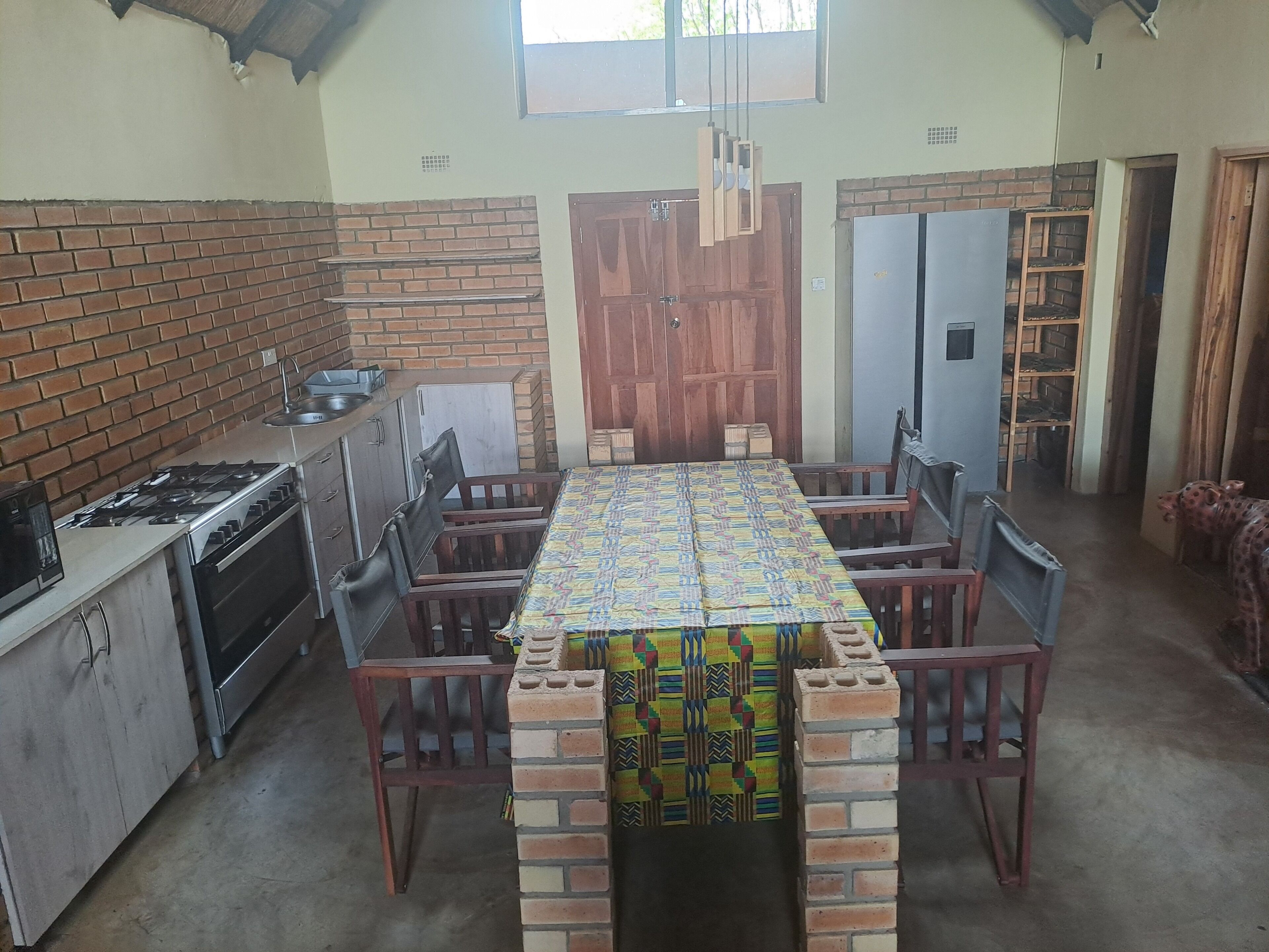 Une cuisine de taille réduite équipée d’une cuisinière à gaz, d’un four et d’une table à manger avec des chaises.