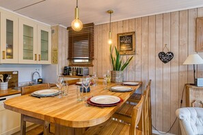 A wooden dining table set with plates, glasses, and cutlery. - Résidence Hélios - centre station (Alpe d'Huez)