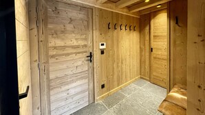 A wooden interior with a door, a bench, and a wall-mounted light fixture. - Duplex Résidence de l'Alpe (Alpe d'Huez)
