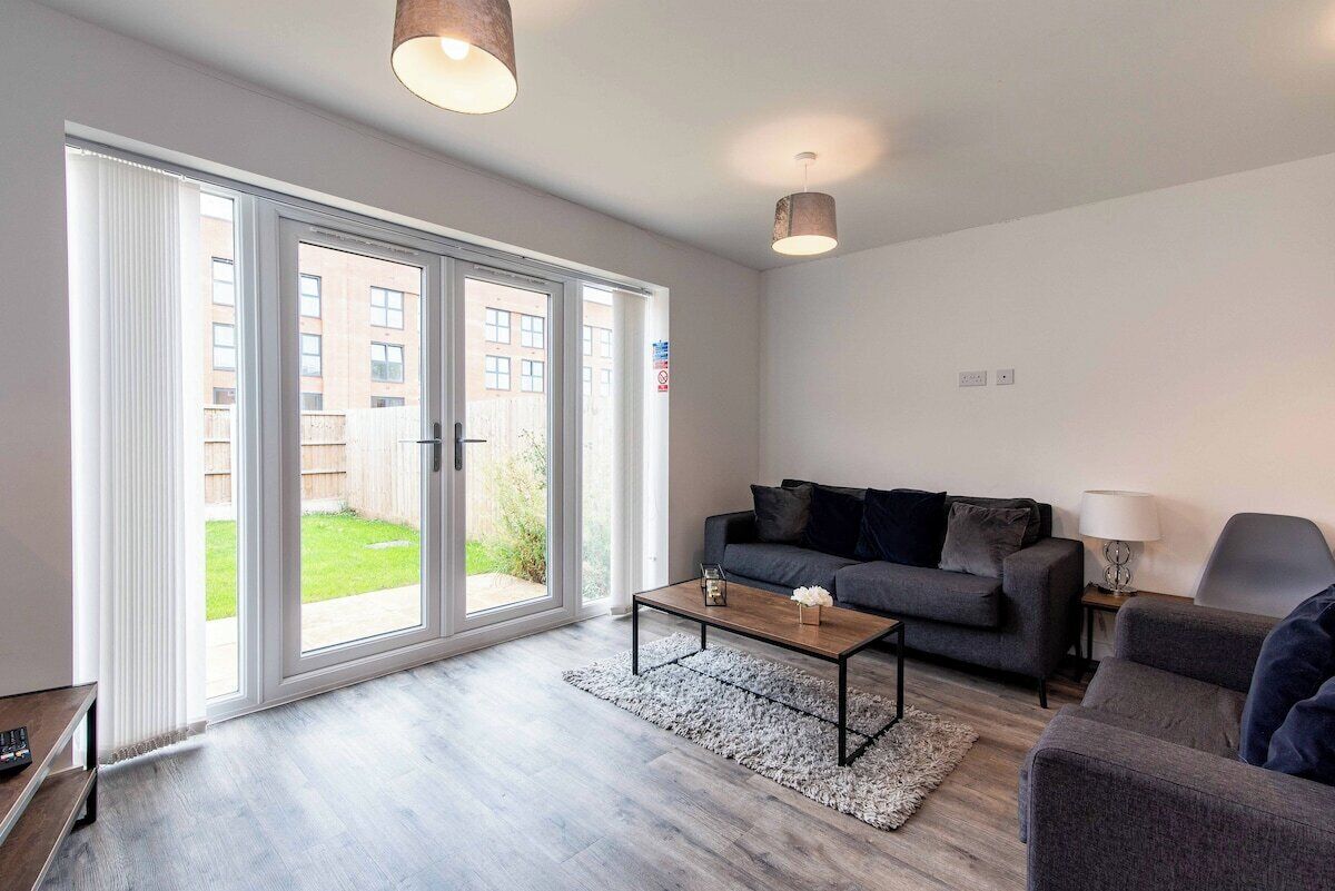 A modern living room with a sofa, a coffee table, and a lamp.