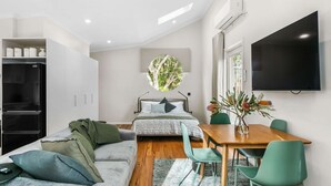 Une chambre à coucher moderne, équipée d’un lit, d’un bureau et d’un téléviseur.