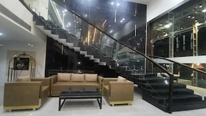 Un intérieur moderne avec un escalier, un ensemble de canapés et une table basse.